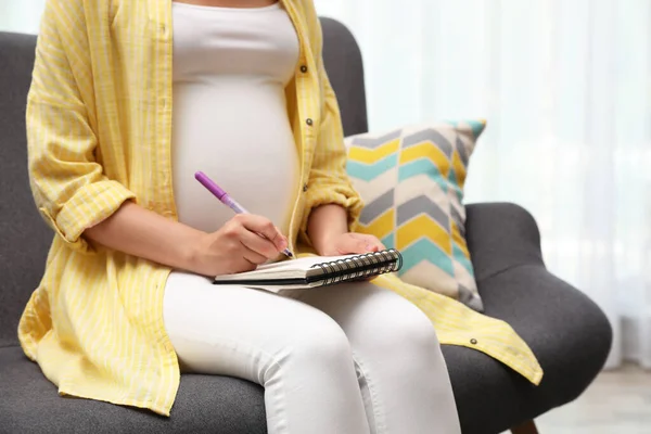 Mujer Embarazada Escribiendo Nombres Bebé Lista Sofá Primer Plano —  Fotos de Stock