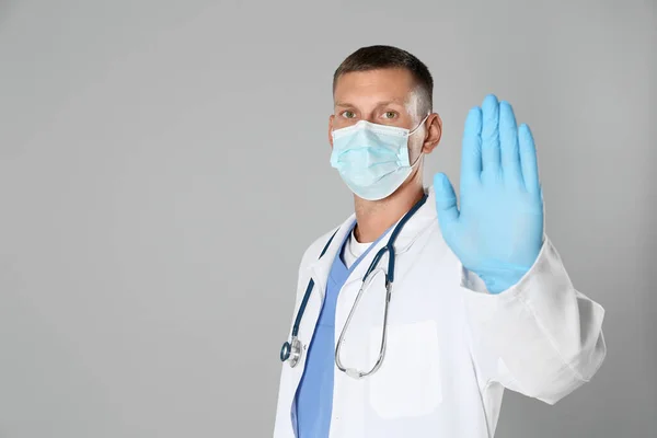 Dokter Beschermend Masker Toont Stop Gebaar Grijze Achtergrond Ruimte Voor — Stockfoto