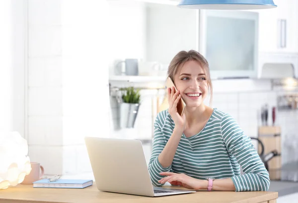 Mujer Joven Feliz Con Portátil Hablando Por Teléfono Casa — Foto de Stock