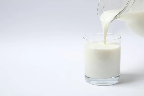 Ρίχνουμε Γάλα Ποτήρι Λευκό Φόντο — Φωτογραφία Αρχείου