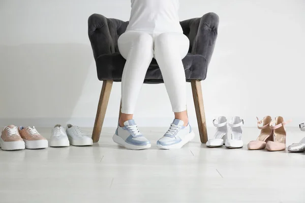 Mujer Joven Eligiendo Zapatos Mientras Está Sentado Sillón Primer Plano — Foto de Stock