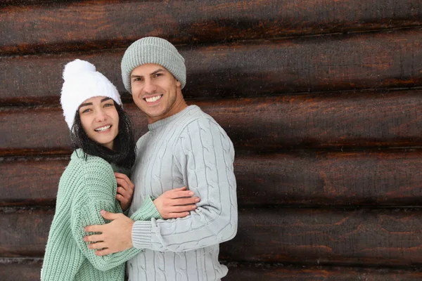 Urocza Para Ciepłych Swetrach Kapeluszach Przy Drewnianej Ścianie Sezon Zimowy — Zdjęcie stockowe