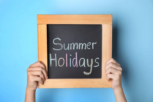 Schoolmeisje Met Schoolbord Met Tekst Summer Holidays Lichtblauwe Achtergrond Close — Stockfoto