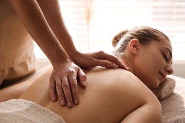 Genç bir kadın güzellik salonunda masaj yaptırıyor.