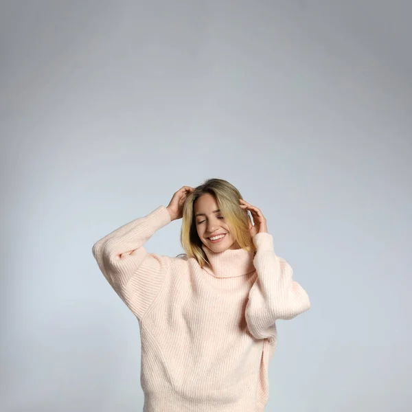 Hermosa Mujer Joven Con Suéter Punto Sobre Fondo Gris Claro —  Fotos de Stock