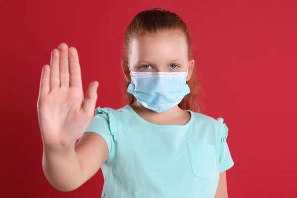 Niña Con Máscara Protectora Mostrando Gesto Stop Sobre Fondo Rojo — Foto de Stock