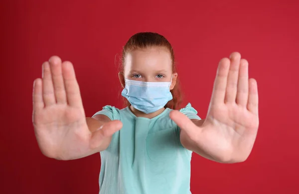 Niña Con Máscara Protectora Mostrando Gesto Stop Sobre Fondo Rojo — Foto de Stock