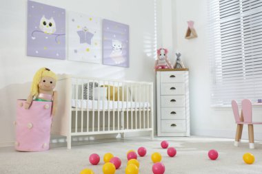 Bebek odasının içinde şirin posterler ve beşikler var.