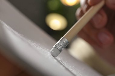 Kağıt üzerinde silgi ile resmi düzelten adam, kapat