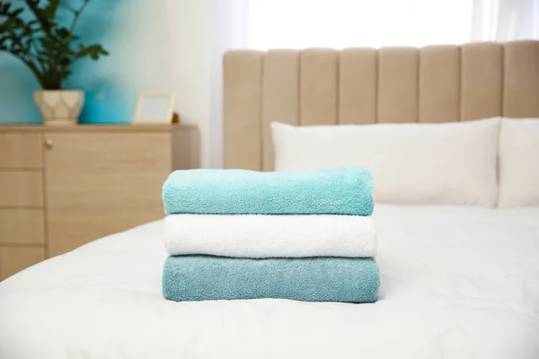 Soft clean towels on bed at home