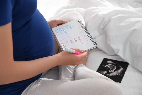 Zwangere Vrouw Met Baby Namen Lijst Echo Zittend Bed Close — Stockfoto