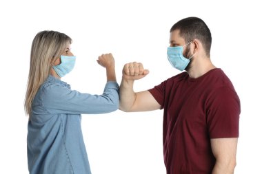 Kadın ve erkek, beyaz arka planda merhaba demek için dirseklerini çarpıştırıyorlar. Koronavirüs salgını sırasında sosyal mesafeyi korumak