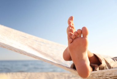 Sahilde hamakta dinlenen adam, yakın plan.