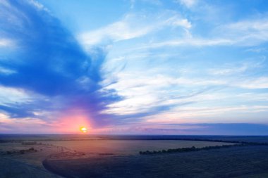 Tarlaların üzerinde inanılmaz bulutlu gökyüzü, hava manzarası. Gün batımı manzarası