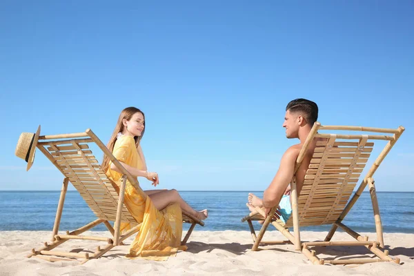 一个女人和她的男朋友坐在海滩的躺椅上 幸福的夫妻 — 图库照片