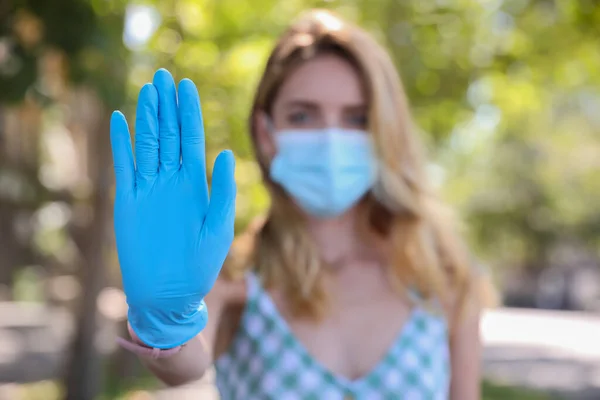 얼굴을 보호하는 마스크를 여자는 실외에서 몸짓을 멈추고 코로나 바이러스의 확산을 — 스톡 사진
