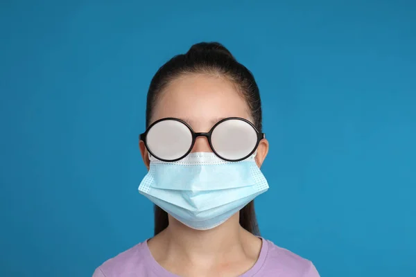 Dziewczynka Mglistych Okularach Spowodowana Medyczną Maską Niebieskim Tle Środki Ochronne — Zdjęcie stockowe
