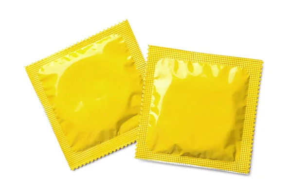 白い背景に黄色のコンドームパッケージ トップビュー 安全なセックス — ストック写真