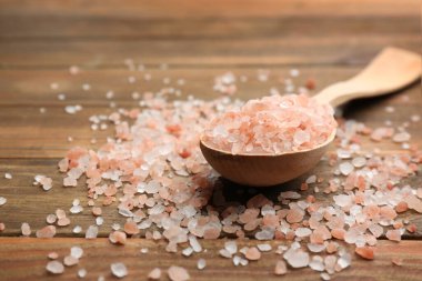 Pembe himalaya tuzu ve kaşığı ahşap masada, yakın plan.