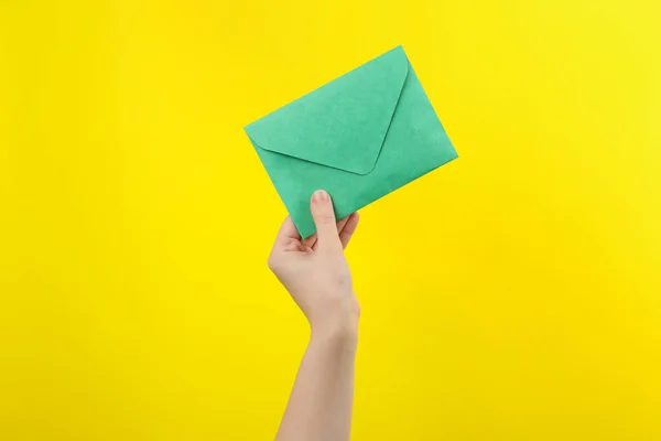 Mulher Segurando Envelope Papel Verde Fundo Amarelo Close — Fotografia de Stock