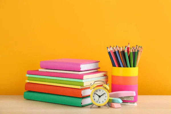 Verschiedene Schulsachen Und Wecker Auf Tisch Vor Orangefarbenem Hintergrund Platz — Stockfoto
