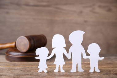 Ahşap masadaki aile figürü ve yargıç tokmağı. Aile hukuku kavramı