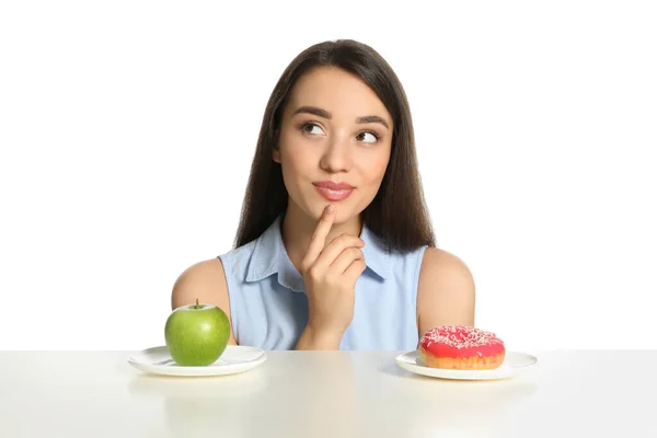 Αμφιβολία Γυναίκα Επιλέγοντας Μεταξύ Μήλου Και Ντόνατ Στο Τραπέζι Λευκό — Φωτογραφία Αρχείου