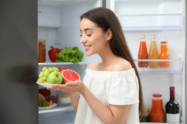 Koncepcja Wyboru Między Zdrową Niezdrową Żywnością Kobieta Gospodarstwa Płyta Owocami — Zdjęcie stockowe