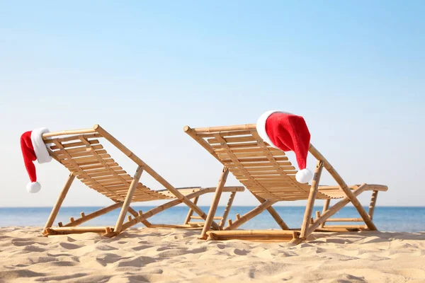 Ligstoelen Met Kerstmanhoeden Het Strand Ruimte Voor Tekst Kerstvakantie — Stockfoto