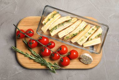 Düz kompozisyon, açık gri masada kesilen beyaz havuç, fırın kabında.