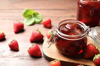 Lezzetli çilek reçeli ve ahşap masada taze böğürtlen.