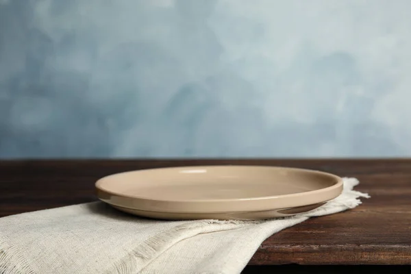 Lege Plaat Servet Houten Tafel Tegen Lichtblauwe Achtergrond Ruimte Voor — Stockfoto