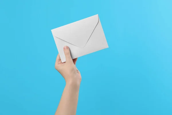 Mulher Segurando Envelope Papel Branco Fundo Azul Claro Close — Fotografia de Stock