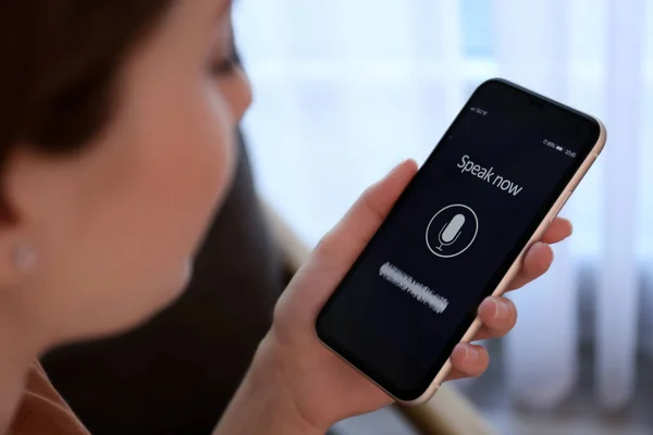 Woman using voice search on smartphone indoors, closeup