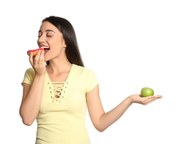 Concepto Elección Mujer Comiendo Donut Sosteniendo Manzana Sobre Fondo Blanco — Foto de Stock