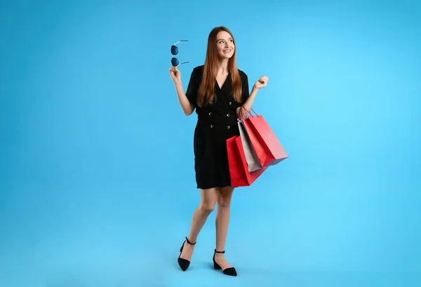 Hermosa Mujer Joven Con Bolsas Compras Papel Sobre Fondo Azul —  Fotos de Stock