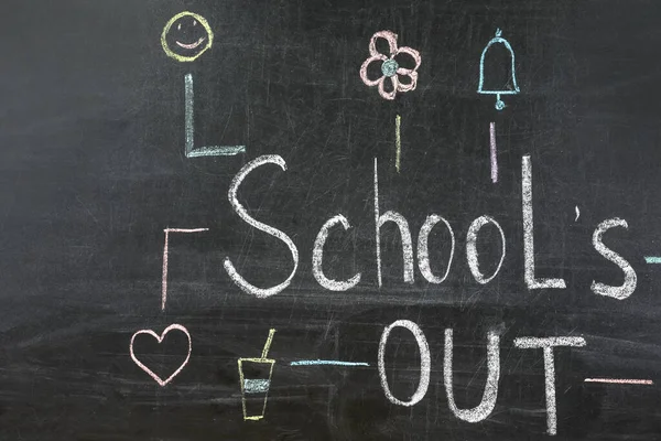 Text School\'s Out and drawings on black chalkboard. Summer holidays