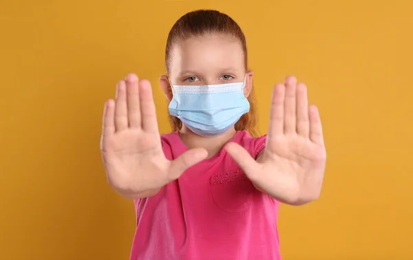Κοριτσάκι Προστατευτική Μάσκα Που Δείχνει Κίνηση Στοπ Κίτρινο Φόντο Πρόληψη — Φωτογραφία Αρχείου