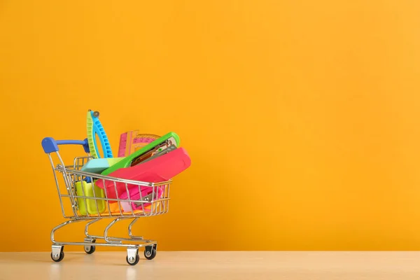 Different School Stationery Miniature Shopping Cart Table Orange Background Space — Stock Photo, Image