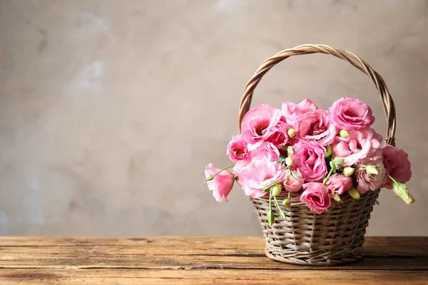 Krásná Růžová Eustoma Květiny Proutěném Koši Dřevěném Stole Šedém Pozadí — Stock fotografie