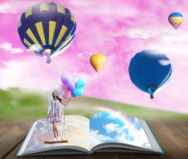 Masallardaki fantezi dünyaları. Kitap, arka plandaki sisli yeşil çayır üzerinde sıcak hava balonları ve pembe gökyüzü.