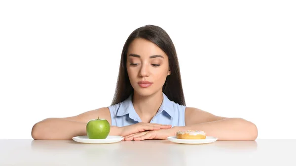 Γυναίκα Επιλέγοντας Μεταξύ Μήλου Και Ντόνατ Στο Τραπέζι Λευκό Φόντο — Φωτογραφία Αρχείου
