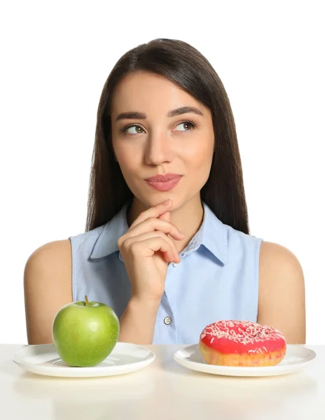 Mujer Dudosa Eligiendo Entre Manzana Donut Mesa Sobre Fondo Blanco —  Fotos de Stock