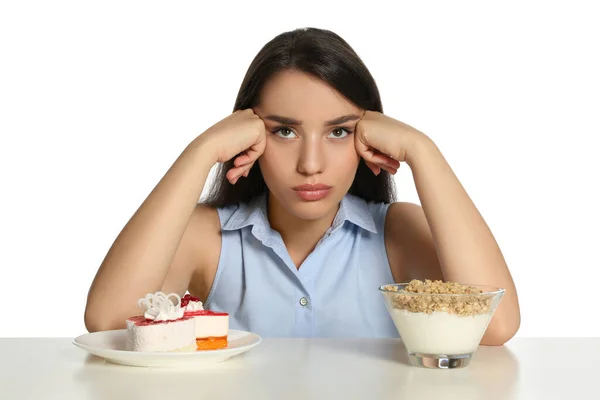 Zweifelhafte Frau Wählt Zwischen Joghurt Mit Müsli Und Kuchen Tisch — Stockfoto