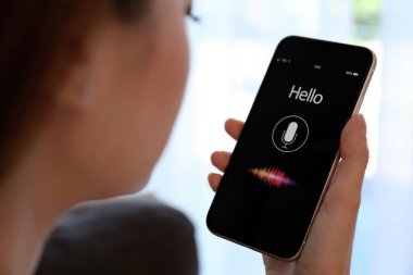 İçerideki akıllı telefondan ses araması yapan kadın, yakın plan.