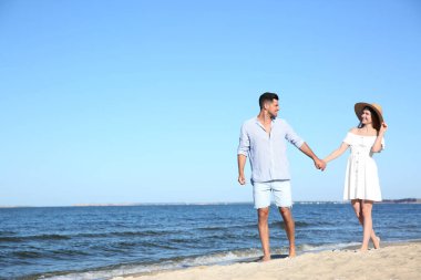 Sahilde yürüyen sevimli bir çift. Metin için boşluk