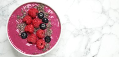 Beyaz mermer masa üzerinde ahududu ve chia tohumlu nefis acai smoothie, üst manzara. Metin için boşluk
