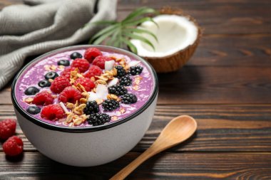 Ahşap masada servis edilen meyveli lezzetli acai smoothie, yakın plan.