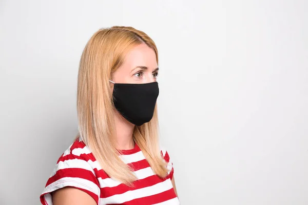 Woman wearing handmade cloth mask on white background, space for text. Personal protective equipment during COVID-19 pandemic