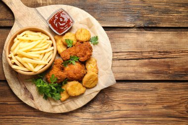 Ahşap masa üzerinde garnitürlü kızarmış tavuk nugget, üst manzara. Metin için boşluk